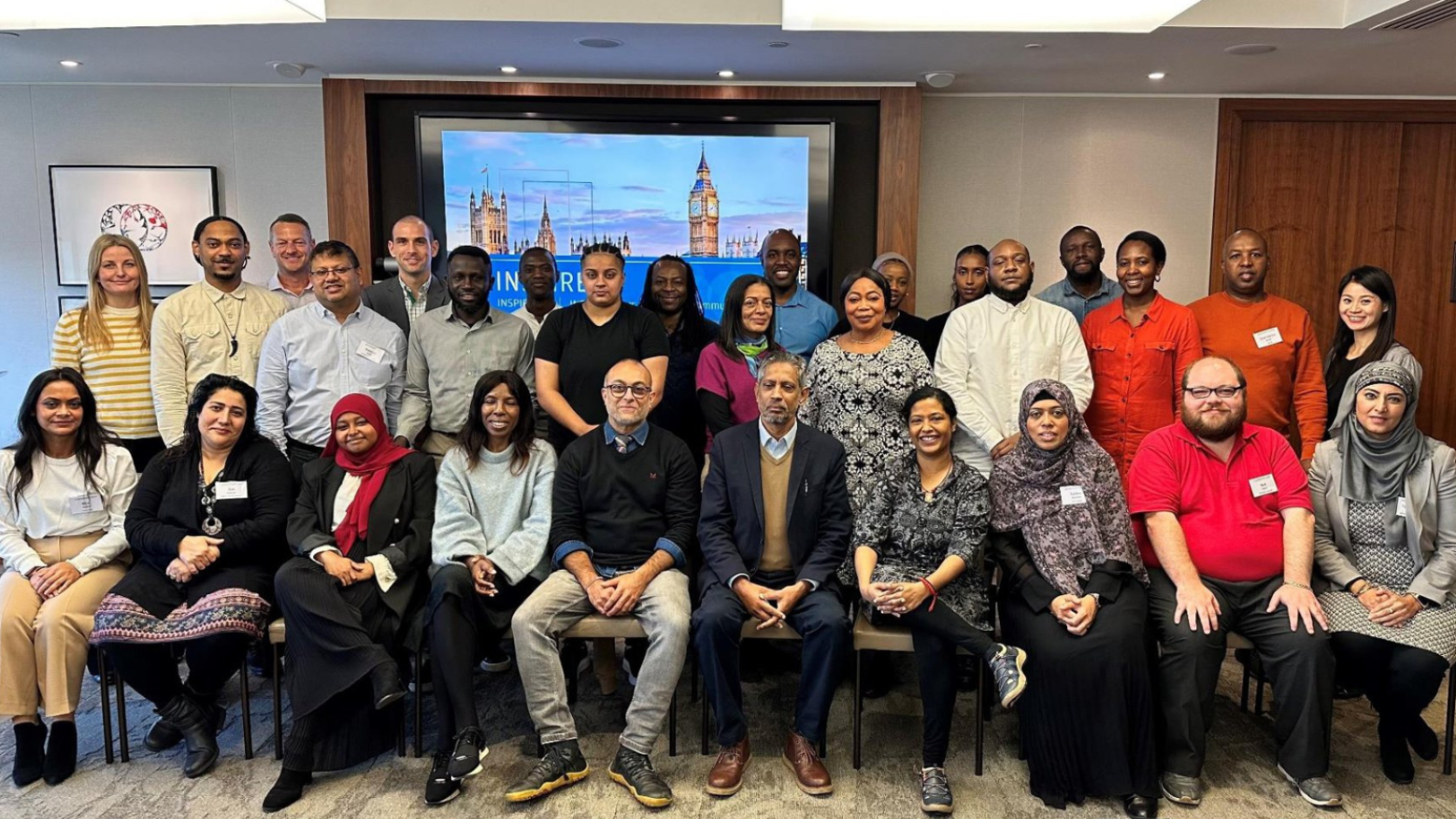 Representatives of the grassroots community groups funded by Pathways to Economic Opportunities programme, sitting and standing together for a photo. These representatives were taking part in the JPMorgan Inspire leadership and organisational development programme.