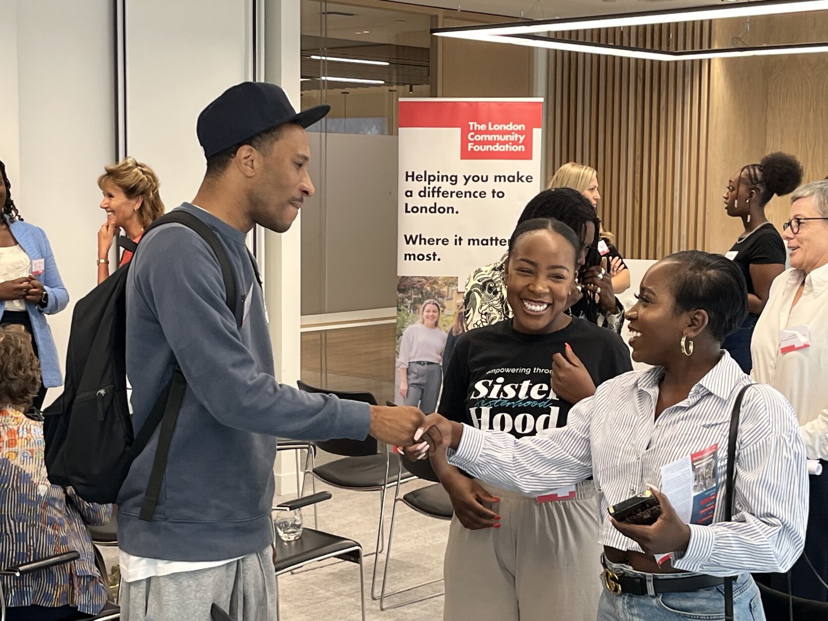 Three people in discussion in a crowded room at the Youth Futures Fund event