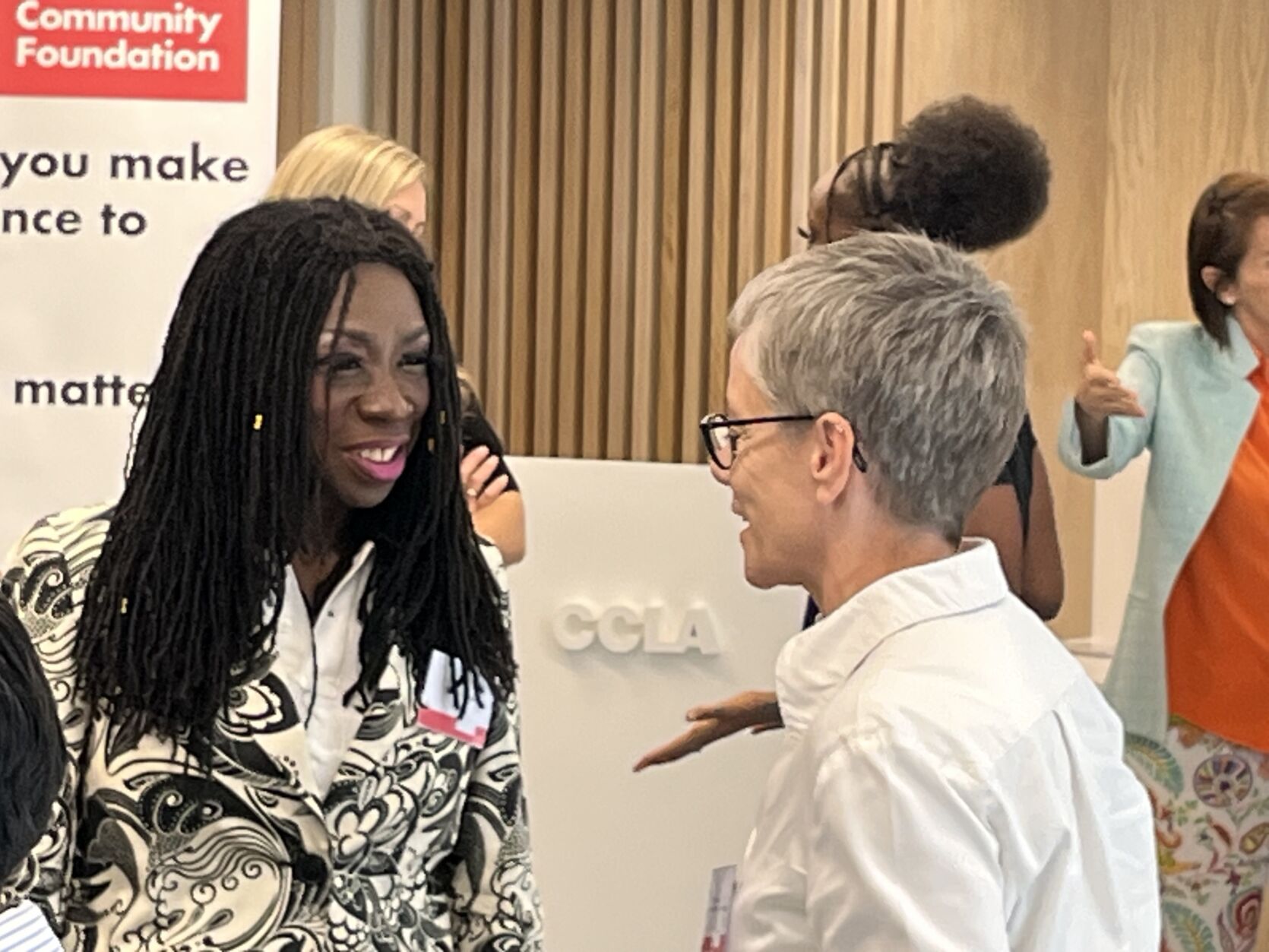 Two people in discussion in a crowded room at the Youth Futures Fund event